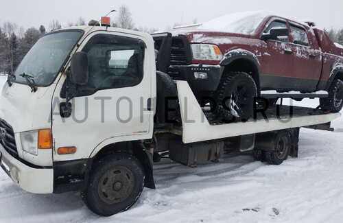 Эвакуатор перевозит внедорожник пикап Dodge RAM